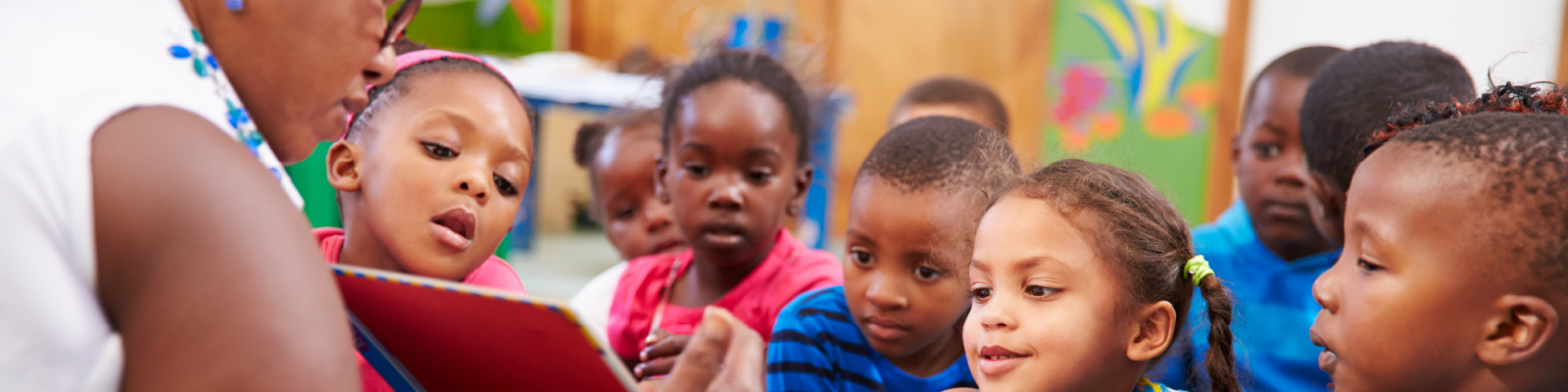 Photo of Adult reading book to kids